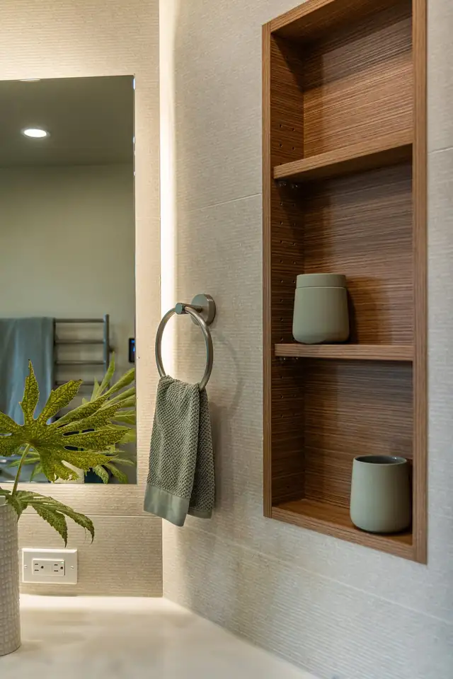 Raleigh Hills primary bathroom with a recessed wood shelving niche, a towel ring and a backlit mirror