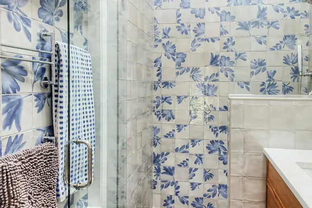 Cedar Hills bathroom with blue and white floral patterned tile and a frameless glass shower door