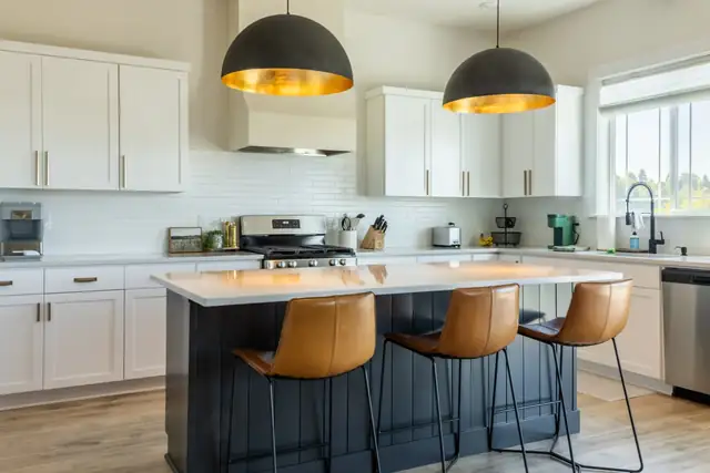 Portland kitchen and living room remodel with navy island, white shaker cabinets, black dome pendants and leather counter stools