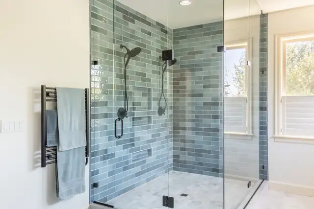 Bull Mountain bathroom remodel in Beaverton with blue-green glazed subway tile shower, black fixtures and heated towel rack