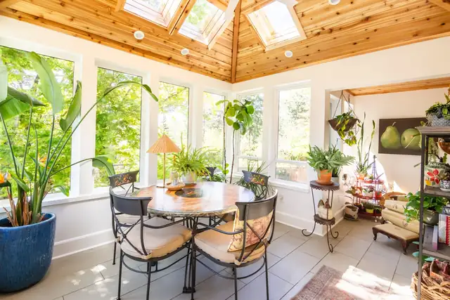 Raleigh Hills atrium with cedar plank ceiling, skylights, round dining table and potted plants